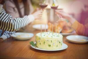 de bonne humeur copains profiter Accueil anniversaire vacances faire la fête. asiatique sœur applaudissement en buvant rouge du vin célébrer avec anniversaire gâteau photo