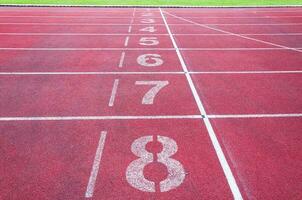 Nombres départ point sur rouge fonctionnement piste, course Piste et vert herbe, directe athlétisme fonctionnement Piste à sport stade photo