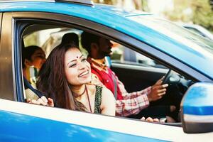 magnifique Indien femme à la recherche à l'extérieur le fenêtre de le voiture où elle est en voyageant ensemble avec sa mari et fille. elle est content et fou de joie photo