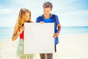 couple sur une plage en portant Vide affiche photo