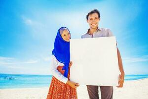 musulman couple sur une plage en portant Vide affiche photo