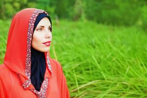 magnifique musulman caucasien femme portant rouge robe et hijab dans le parc photo