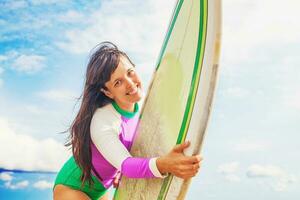 Jeune femme en portant une le surf planche photo