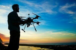 tenue d'homme une drone pour aérien la photographie. silhouette contre le le coucher du soleil ciel photo