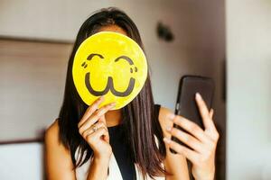 Jeune Indien femme prise une selfie avec sa visage couvert par un emoji photo