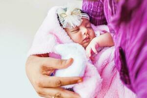 peu nouveau née Indien fille en train de dormir dans le mains de sa père photo