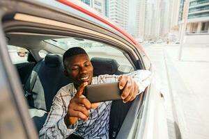 africain homme en portant une téléphone dans le voiture photo