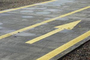 piste en béton avec des lignes jaunes et des flèches photo