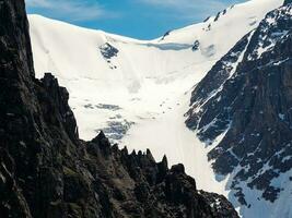 impressionnant scénique Montagne paysage avec gros fissuré pointu des pierres fermer parmi neige en dessous de bleu ciel dans lumière du soleil. tranchant rochers Contexte. photo