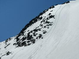 longue pied Piste sur le clair neige pente Aller dans le distance. neige pente. diagonale arrangement. photo