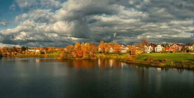 large panorama de le spectaculaire campagne avec chalets et Jaune des arbres sur le Lac rive. photo