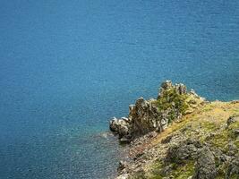 magnifique la nature Contexte de pierreux bas dans turquoise transparent l'eau de glacial Lac dans lumière du soleil. ensoleillé toile de fond avec beaucoup des pierres dans vert clair l'eau de glacier lac. photo