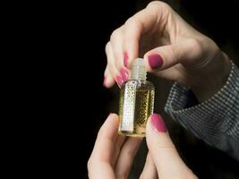 européen mains de une femme avec arabe parfum huile. photo