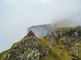 de mauvaise humeur des nuages couvrant le Haut de le montagnes. moussu des pierres dans vert ravin. photo