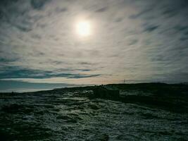 clair de lune plus de une vieux délabré maison sur une rocheux rive. nuit mystique paysage. hiver téribère. photo