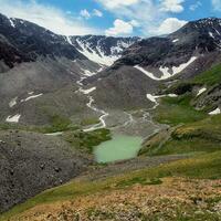 dans le vallée là est une bleu Lac avec raide rocheux rivages. Montagne intervalle contre une bleu ciel. caldeira de un disparu volcan est entouré par une Montagne gamme. carré voir. photo