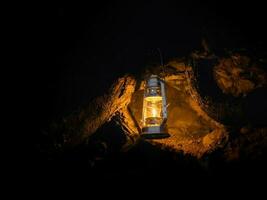 Jaune pendaison lanterne à le entrée à le grotte, terrier à nuit photo