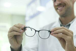 opticien suggérant Nouveau lunettes Cadre à clients. photo