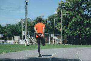 Jeune homme coureur élongation jambes. photo