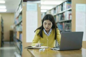 étudiant en train d'étudier à bibliothèque avec portable. photo