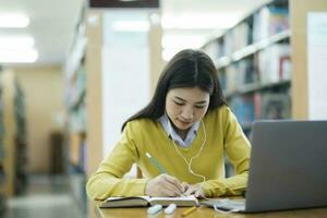 étudiant en train d'étudier à bibliothèque avec portable. photo