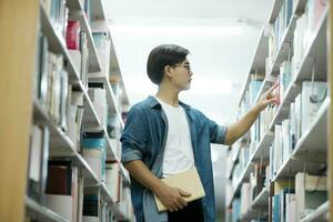 étudiant en train de lire livre à bibliothèque. photo