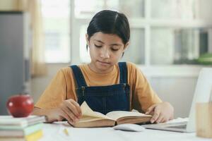 asiatique fille en train de lire et Faire devoirs à sa Accueil photo