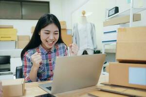 Jeune asiatique femmes content après Nouveau commande de client. photo