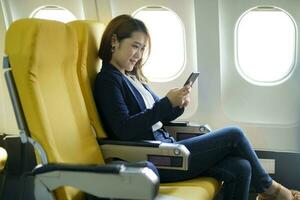 affaires femme travail en utilisant téléphone tandis que séance dans avion. photo