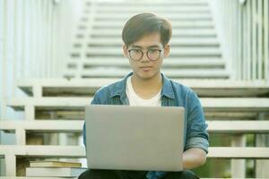 étudiant en train d'étudier Extérieur en utilisant portable. photo