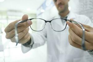 opticien suggérant Nouveau lunettes Cadre à clients. photo