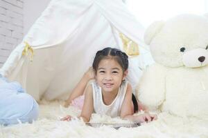 content les enfants fille donc mignonne souriant tandis que à maison. photo