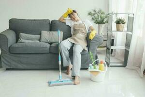 épuisé femme repos après nettoyage maison. photo