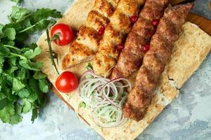 Assiettes de viande avec barbecue et kebab sur fond gris photo