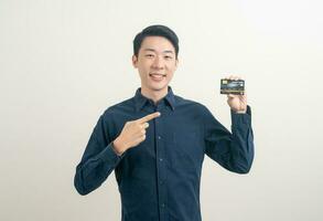 jeune homme asiatique tenant une carte de crédit photo