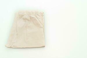 pli de pantalon beige sur fond blanc photo