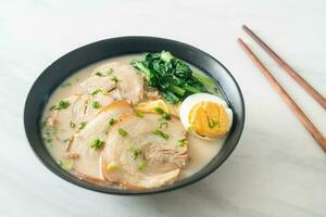 nouilles ramen dans une soupe d'os de porc avec du porc rôti et des œufs photo