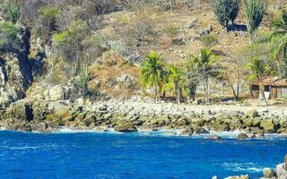 surfeur vagues turquoise bleu l'eau rochers falaises rochers puerto escondido. photo