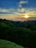 pittoresque vue de coloré le coucher du soleil ciel plus de forêt. photo