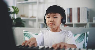 mignonne garçon prendre plaisir à apprentissage en jouant piano à Accueil photo