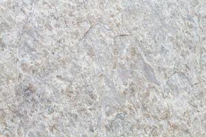 Texture de fond en pierre naturelle rugueuse avec des tons gris blancs et bruns