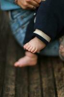 nouveau née dans mère est bras. alimentation le bébé. enfant est jambes. maman des promenades avec bébé photo