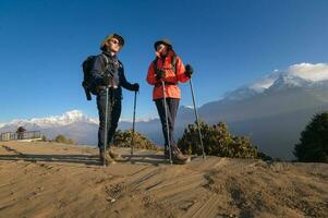 une Jeune couple voyageurs trekking dans poon colline vue point dans ghorepani, Népal photo