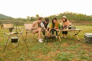 groupe de Jeune asiatique gens sont prendre plaisir camping dans Naturel site de camp photo