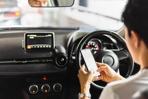 homme utilisant un smartphone tout en conduisant une voiture photo