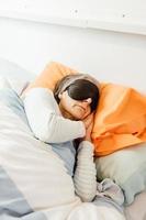 Une vieille dame endormie à l'aide d'un masque facial dans une chambre moderne photo