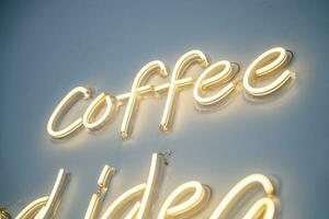 une Jaune néon signe sur blanc mur à café magasin. photo