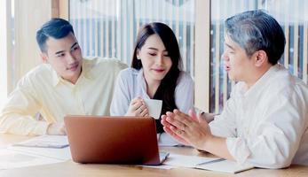 Les hommes d & # 39; affaires asiatiques enseignent des emplois aux nouvelles générations dans le concept de travail d & # 39; équipe de bureau photo