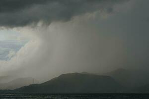 orage plus de le mer avec montagnes dans le Contexte photo