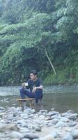 gorontalo-indonesie, mai 2023 - Jeune homme profiter le Matin atmosphère par le au bord de la rivière photo